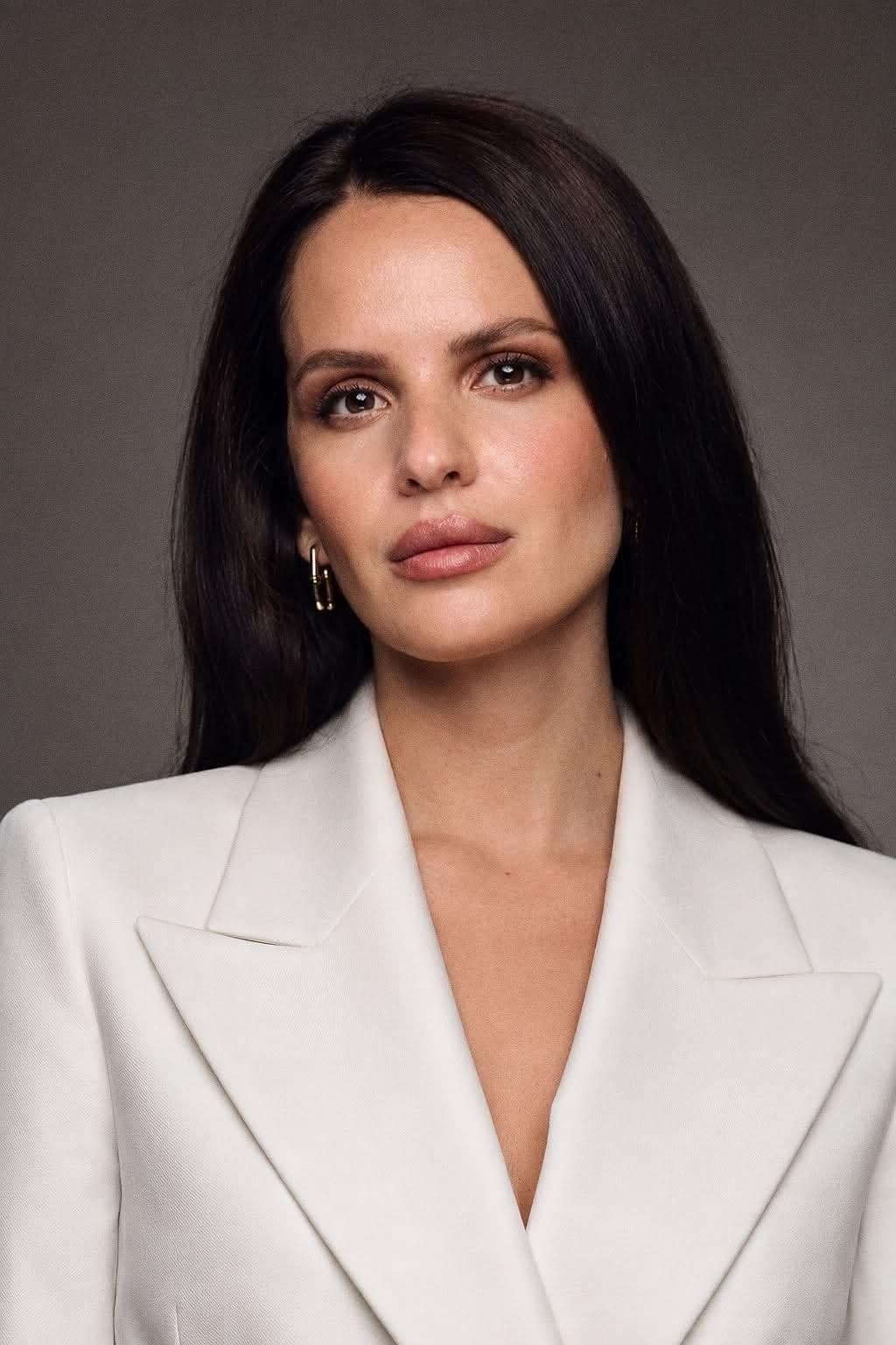 Anna Bon, portrait in a white jacket against a dark ground.